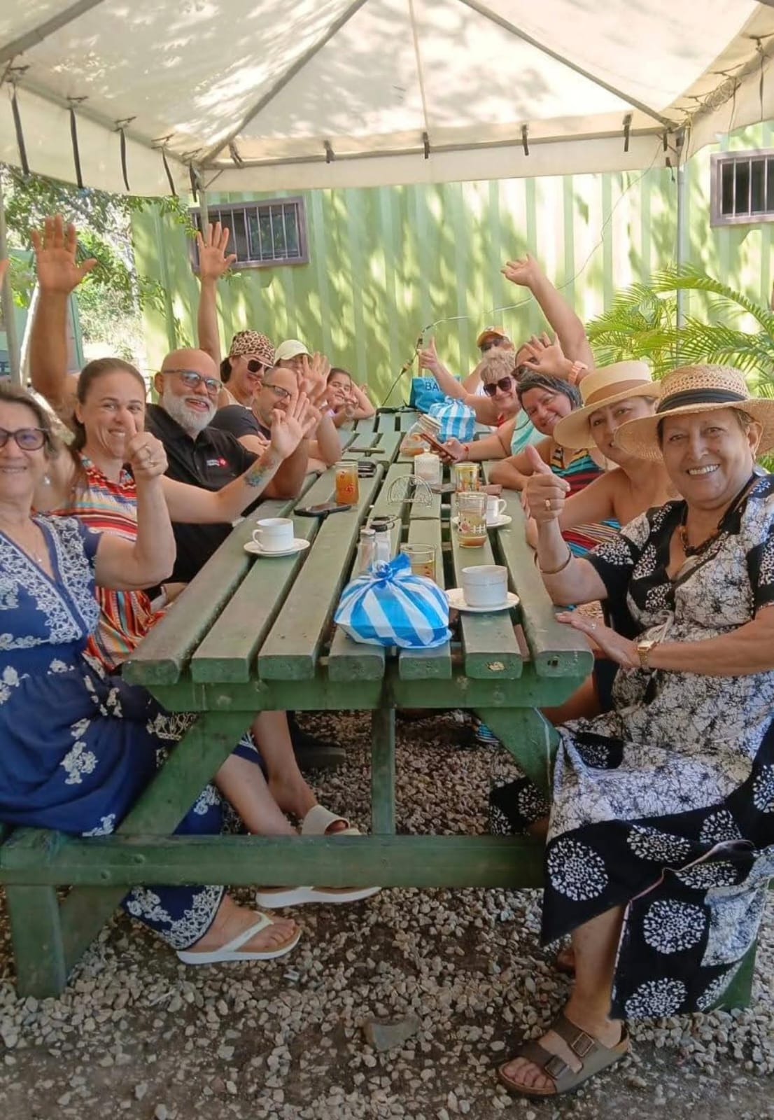 Grupo en una mesa larga del centro, saludando a la cámara