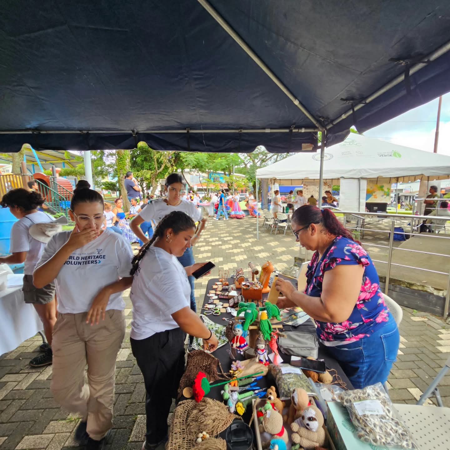 Tejidos, joyería y bolsos de fibra bajo el toldo de la feria