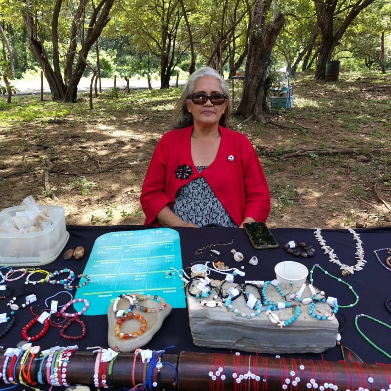Artesana con pulseras de cuentas, conchas y semillas