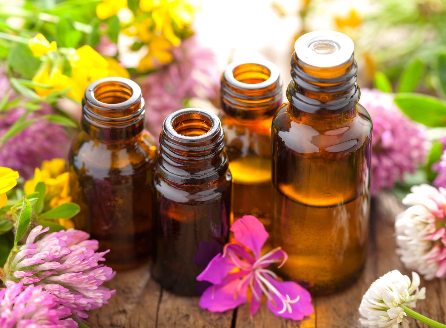 Frascos de aceite esencial entre flores silvestres